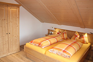 Schlafzimmer mit Doppelbett und Zugang zum Balkon