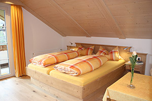 Schlafzimmer mit Doppelbett und Zugang zum Balkon